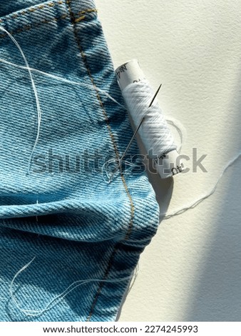 needle and thread. mending jeans