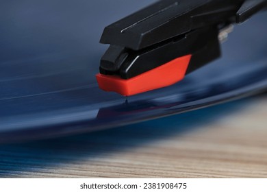Needle of vinyl player is mounted on record. Closeup on macro photos