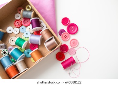 needlework, craft, sewing and tailoring concept - box with thread spools and buttons on table - Powered by Shutterstock