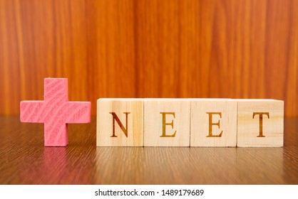 NEET A Medical Exam Conducted At India In Wooden Block Leters On Table.