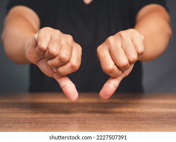Negative concept. Close-up of young man's hands showing a thumbs down for dislike service. Customer service and satisfaction surveys concept