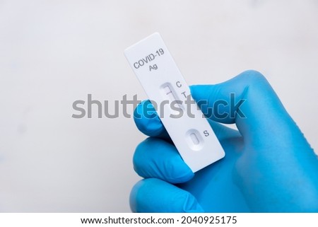 Negative Covid-19 antigenic test for quick detection of disease in doctors hand in the rubber gloves with copy space. Coronavirus test cassette from rapid strep kit. 