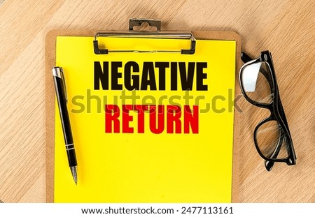 NEGATIVE RETURN text on a yellow paper on clipboard with pen and glasses. 