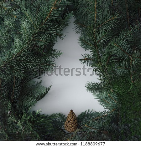 Negative space Christmas tree concept. Creative winter layout made with evergreen tree branches. Flat lay.
