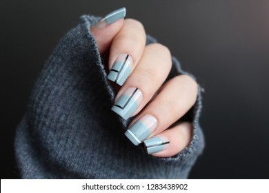 negative space manicure  of gray nail polish with black and white stripes design