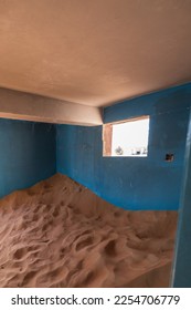 Neglected house interior with blue walls buried in the sand in Al Madam ghost village in United Arab Emirates. - Shutterstock ID 2254706779