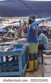 Negombo, Sri Lanka - 13 Sep,2022: Middle Age Sri Lankan Man Wearing Boots And Waiting For Customers At Fish Market At Negombo. Daily Work Of Worker At Fish Market.