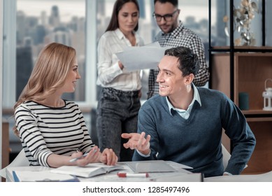 Negotiating. Alert blond woman smiling and talking with her co-worker - Powered by Shutterstock