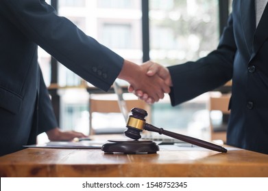 Negotiation of legal agreements. Businessmen and lawyers join hands after the negotiation ends.