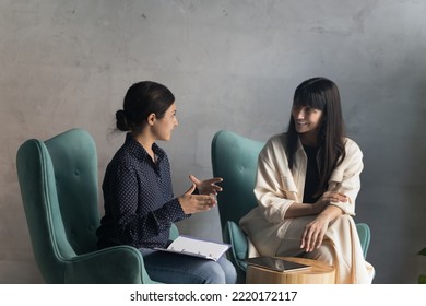 Negotiations of two multi ethnic businesswomen in modern office. Indian female applicant pass job interview, answers to HR manager during formal meeting in workspace. Teamwork, business, communication - Shutterstock ID 2220172117
