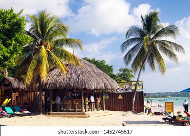 NEGRIL, JAMAICA - MAY 24. 2010: Bamboo Bar With Thatched Roof And Palm Trees On Bourbon Beach