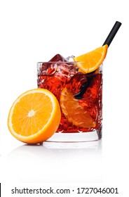 Negroni Cocktail In Crystal Glass With Ice Cubes And Orange Slices With Straw And Half Of Fresh Orange On White Background With Reflection.