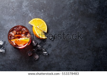 Negroni cocktail on dark stone table. Top view with space for your text