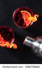 Negroni Cocktails With Blood Oranges And Peel, Shot From Above On A Black Background