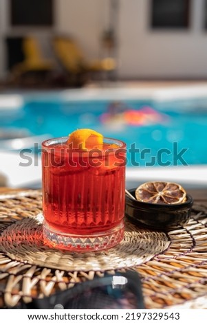 Negroni at poolside. Classic cocktail Negroni with gin, campari and martini rosso. Traditional recipe