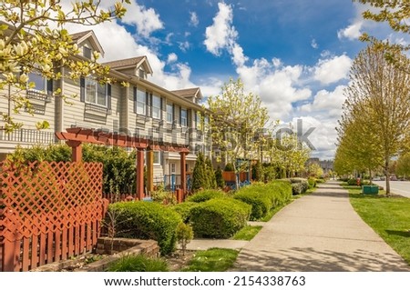 Neighborhood modern houses with spring flowers in BC, Canada. Canadian modern residential architecture. Nobody, street photo