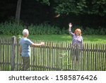 Neighbors greeting each other over fence