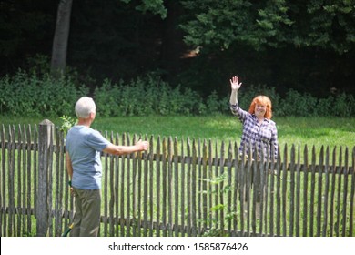 Neighbors Greeting Each Other Over Fence