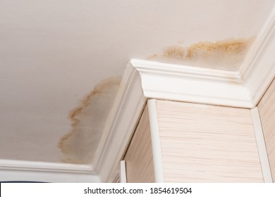 Neighbors have a water leak, water-damaged ceiling, close-up of a stain on the ceiling. - Shutterstock ID 1854619504