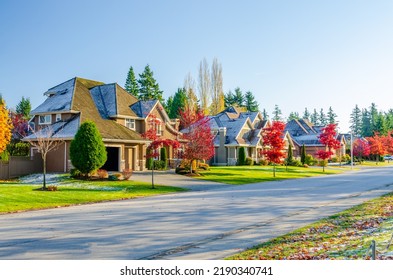 Neighbourhood of luxury houses with street road, big trees and nice landscape in Vancouver, Canada. Blue sky. Day time on September 2021.