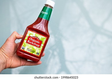 Nellysford, USA - April 29, 2021: Closeup Of Sign For Ketchup And Hand Holding Organic Private Label Brand Bottle From Trader Joe's