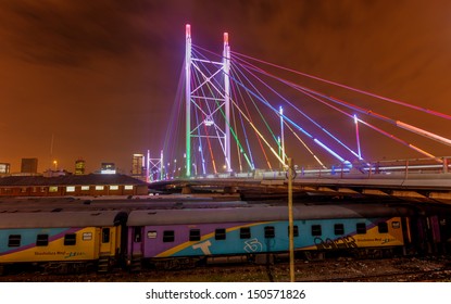 Nelson Mandela Bridge at night. The 284 meter long Nelson Mandela Bridge connecting Newtown, which was opened by Nelson Mandela himself. Seen over the 40 railway lines it helps traverse. - Powered by Shutterstock