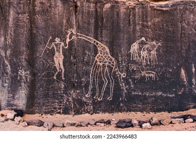 Neolithic rock art. Prehistoric rock engraving  depicting a human and a giraffe. Tadrart Rouge. Tassili N'Ajjer National Park.Sahara Algerian Desert. Illizi Province, Djanet, Algeria, Africa   - Shutterstock ID 2243966483