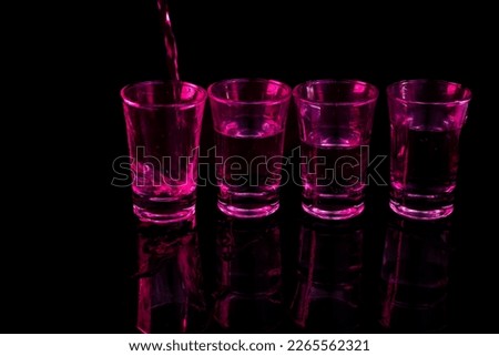 neon alkohol  in glasses,part with alkohol,glasses with alcohol on black background,glasses of vodka