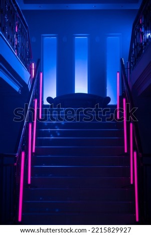 Neon Background. Dark blue and red neon stairs at the night. Night club, bar, concert or studio room. Fluorescent laser light. 