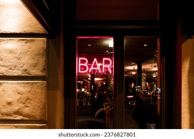 Neon Bar sign in the window of european city bar at night