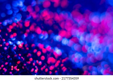 Neon bokeh light. Blur circles glow. Cyber glare. Defocused fluorescent navy blue magenta pink color round sparks flare on black futuristic abstract background.