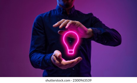 Neon colored light bulb between male hands. Businessman generating innovative, creative, profitable ideas, project, startup. Concept of technologies, data science, programming, business, brainstorming