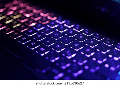 Neon computer keyboard with color backlight. Computer video games, hacking, technology, internet concept. Selected focus.