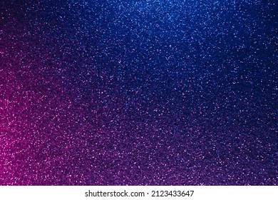 Neon glitter background. Grain texture. Defocused sparkles. Bokeh glow. Fluorescent blue magenta pink color gradient light shimmering sequin pattern.