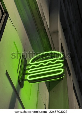 Neon green shake shack logo in Uk Oxford street.
