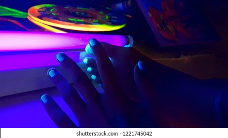 Neon Light Blue Nail Polishes In Blacklight Light.