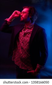 Neon Light Portrait Of Handsome Male Model With Dark Medium Length Hair, Mustaches And Beard In Sunglasses, Weared In Dark Jacket And Floral Shirt.