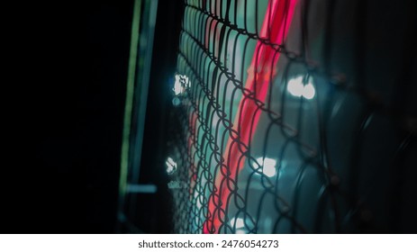 A neon lit fence with A Neon Light on it. - Powered by Shutterstock