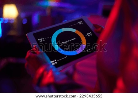 Neon metaverse futuristic concept. Closeup on woman using tablet PC and exploring charts in office.