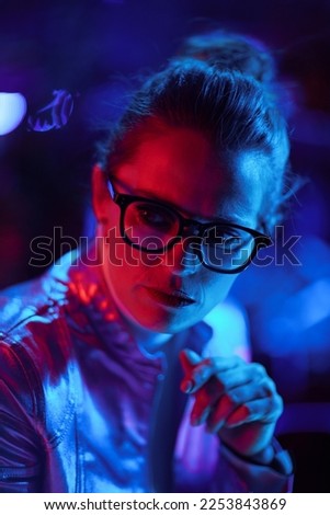 Neon metaverse futuristic concept. concerned modern business woman in glasses.