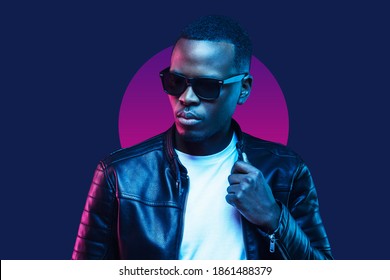 Neon portrait of african american man, wearing sunglasses and leather jacket, isolated on blue background