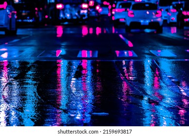 Neon reflection from street asphalt with pedestrian walking by. Futuristic city and cyberpunk concept.