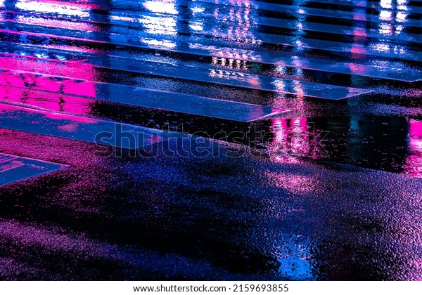 Neon reflection\
from street asphalt with pedestrian walking by. Futuristic city and\
cyberpunk concept.