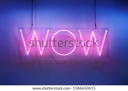 Neon shine electricity fluorescent sign “Wow” concept illuminated vintage retro club glow icon logo text light WOW billboard signboard trend funny entertaining emotion nightlife in pink blue colors
