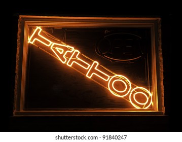 Neon Sign In Display Window Of Tattoo Parlor