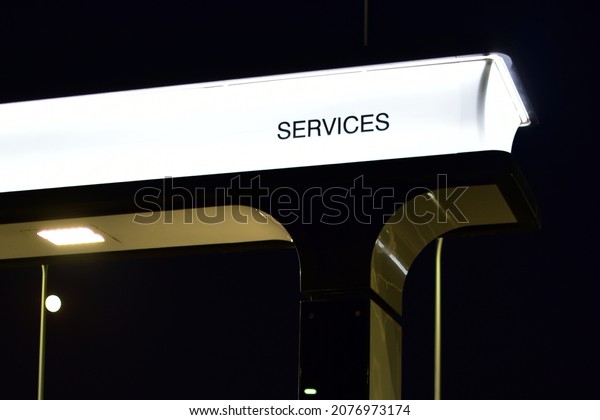Neon sign -\
SERVICES - on dark night\
background