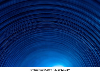 Neon Tunnel. Defocused Glow Background. Arc Shape Pattern. Fluorescent Illumination. Blur Blue Color Light On Dark Curved Grooved Texture Abstract Overlay.