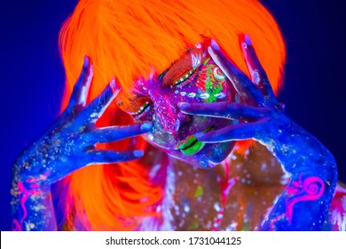 Neon Woman dancing. Fashion model woman in neon light, portrait of beautiful model with fluorescent make-up, Art design of female disco dancer posing in UV, colorful make up