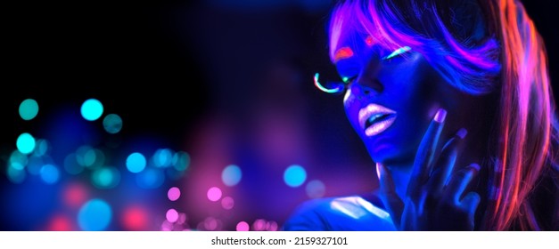 Neon Woman dancing. Fashion model girl in neon light, portrait of beautiful model with fluorescent make-up, Night club. Disco dancer posing in UV, colorful make up. On bright background. 