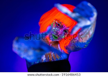 Neon Woman dancing. Fashion model woman in neon light, portrait of beautiful model with fluorescent make-up, Art design of female disco dancer posing in UV, colorful make up
